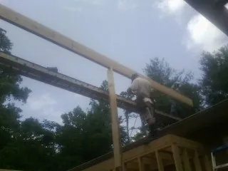 Carpenter setting a ridge beam over a new addition frame — Ice Dam Removal by Roofing Brothers in Tieton